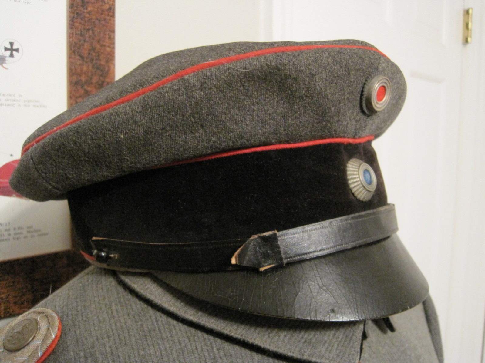 An Imperial German officer visor cap for Prussian Regiments, Dark blue cap  body, red band, red piping, black visor, officer Prussian and national  cockades, brown leather sweatband with fine white silk lining.