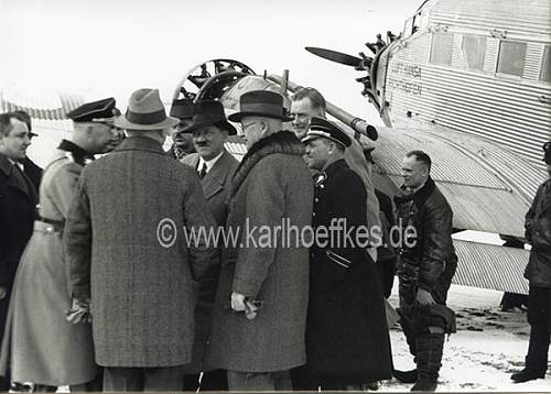 Himmler and Wolff in grey overcoat with black collar and black cap....