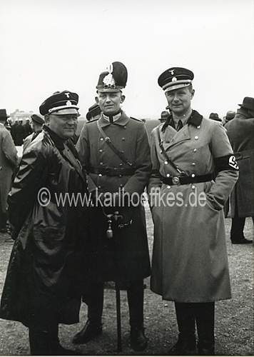 Himmler and Wolff in grey overcoat with black collar and black cap....